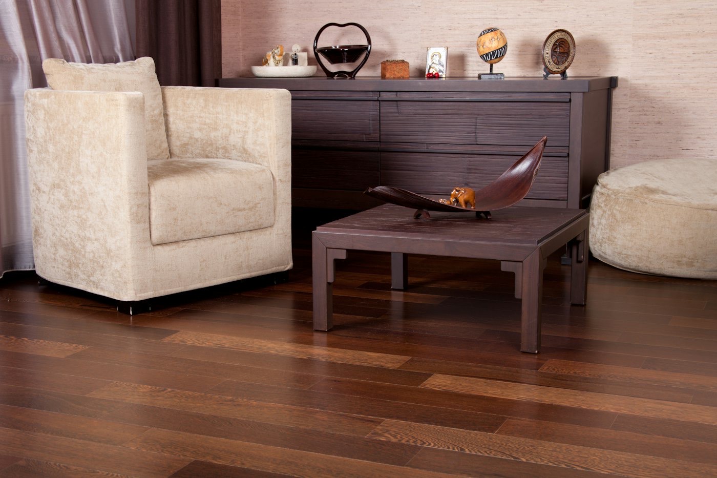 A living room with wide wood floorboards and a grey sofa