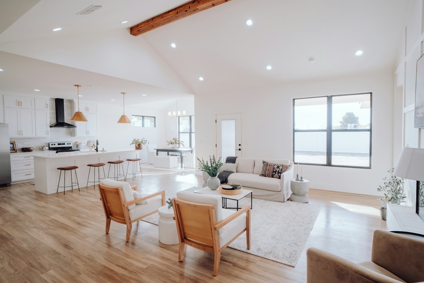 A bright open-plan living space with a kitchen at the far end
